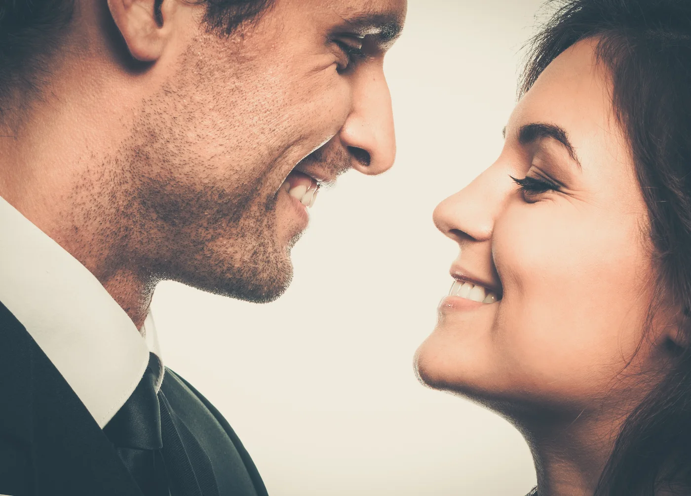 Casal sorrindo bem de perto, à vontade e sem receio